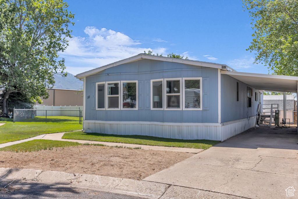 View of front of house with concrete driveway and an attached carport