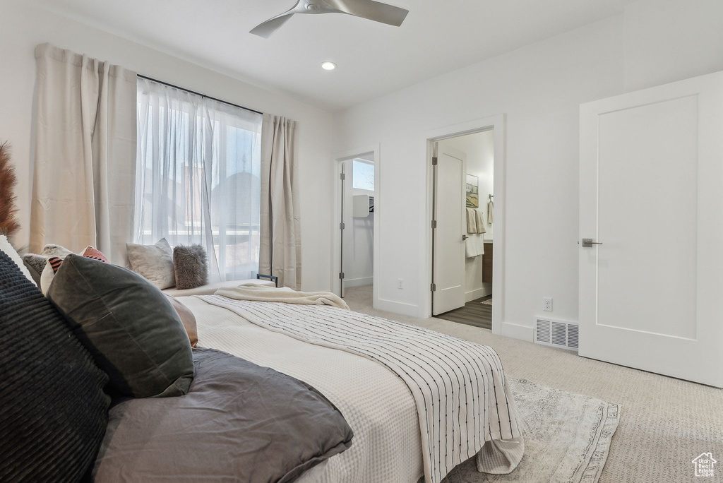 Bedroom with light colored carpet, a spacious closet, a ceiling fan, ensuite bathroom, and recessed lighting