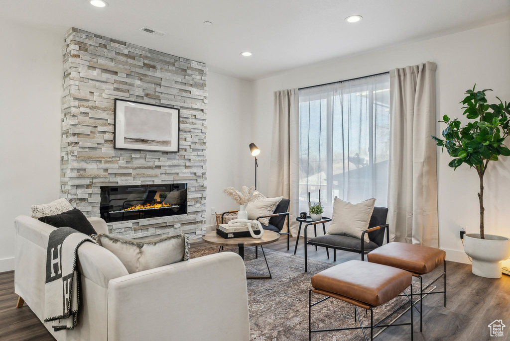 Living area with a fireplace, wood finished floors, and recessed lighting