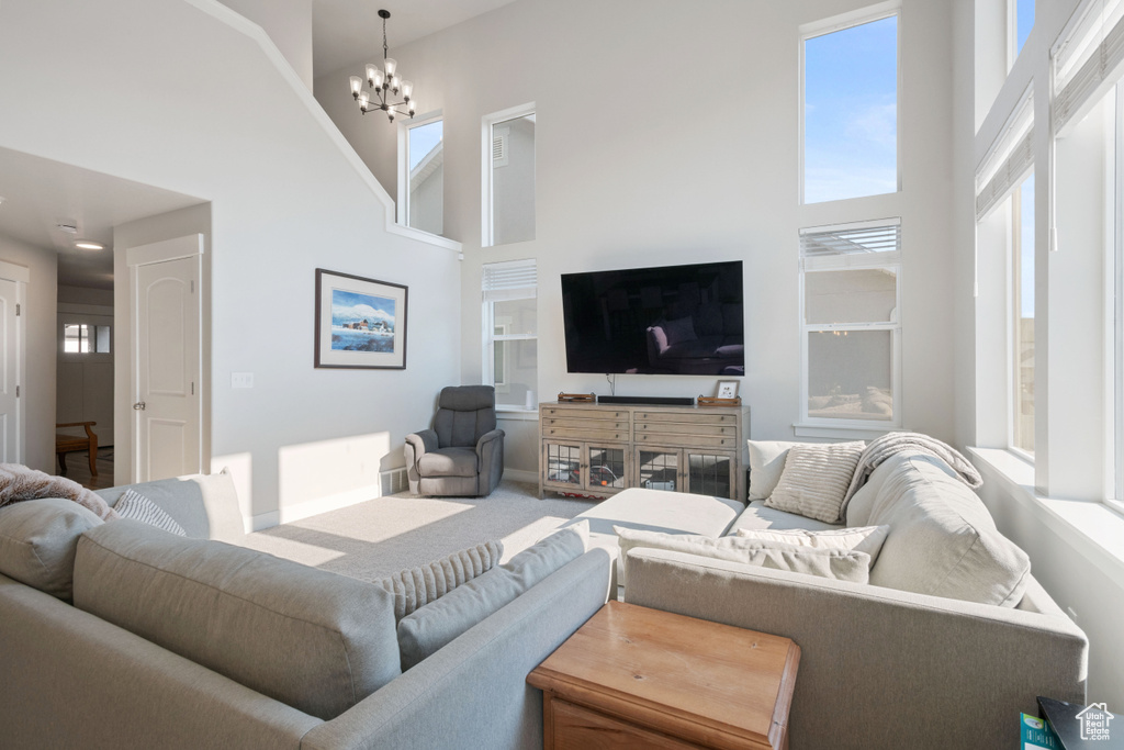 Living area featuring a high ceiling and a chandelier