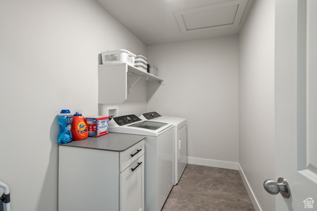 Laundry area featuring independent washer and dryer and cabinet space