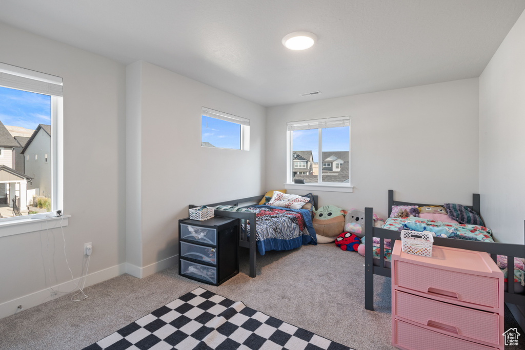 Bedroom with light colored carpet and baseboards