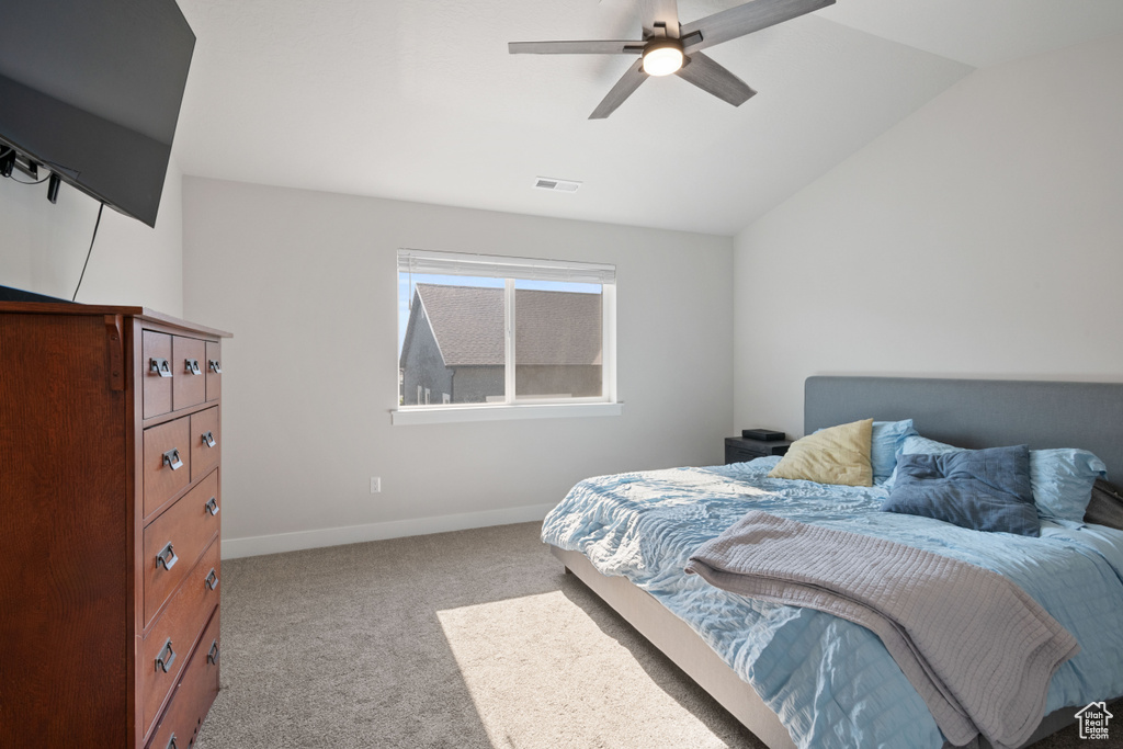 Carpeted bedroom with lofted ceiling and a ceiling fan