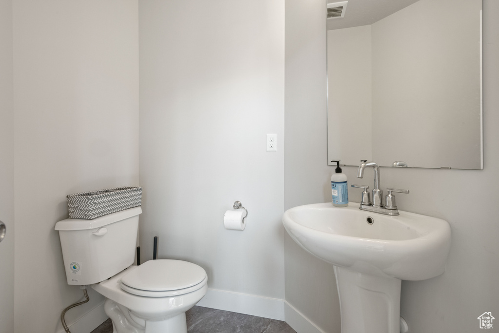 Half bath with toilet and baseboards