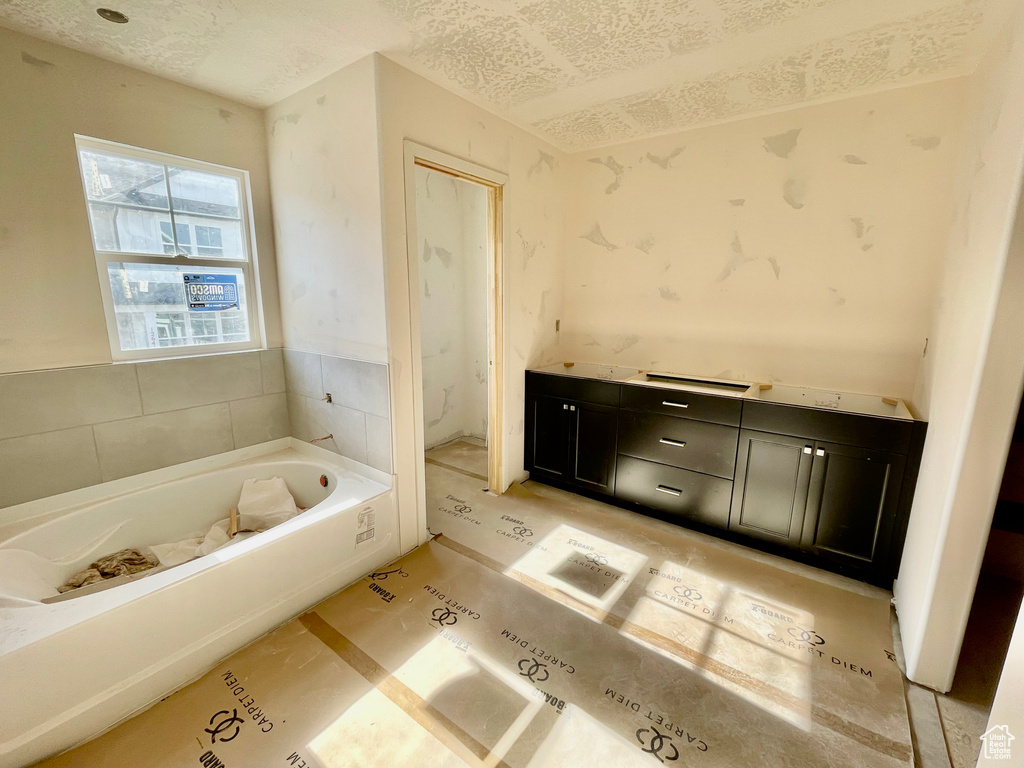 Bathroom with a bath and a textured ceiling