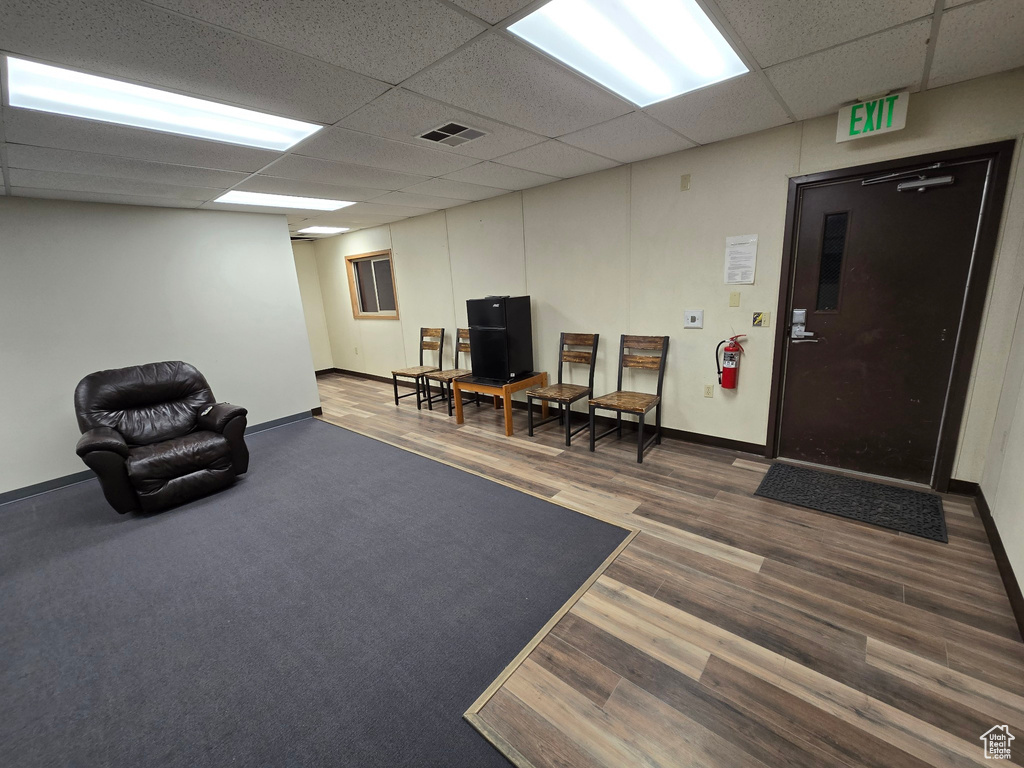 Living area with a drop ceiling and wood finished floors