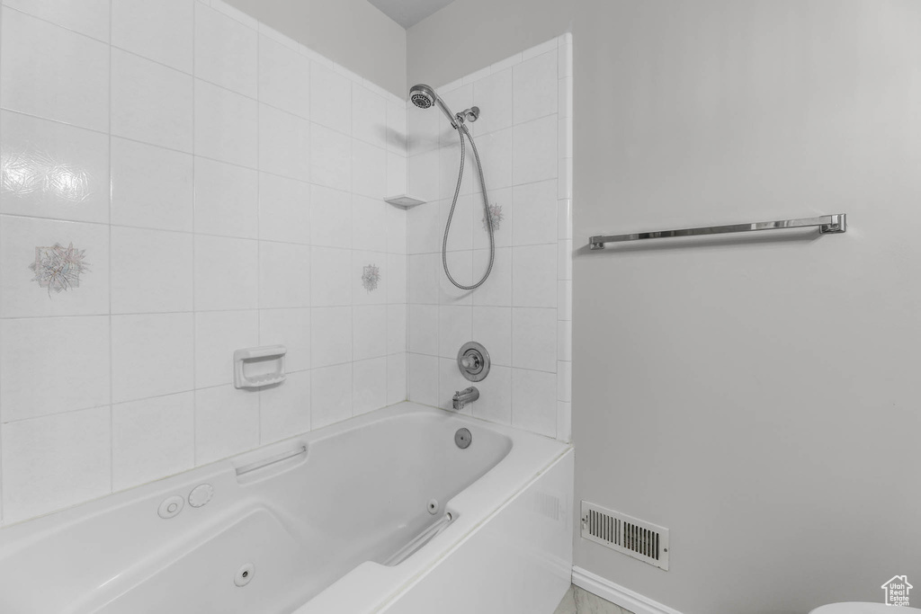 Full bathroom with a combined bath / shower with jetted tub and baseboards