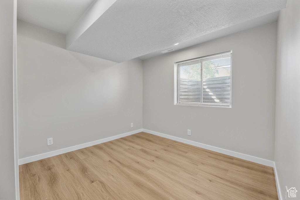 Unfurnished room featuring wood finished floors and a textured ceiling