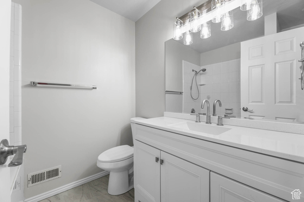 Full bathroom featuring marble look tiles, vanity, and a shower
