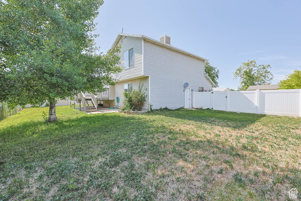 View of side of property with a fenced backyard, a gate, and a chimney