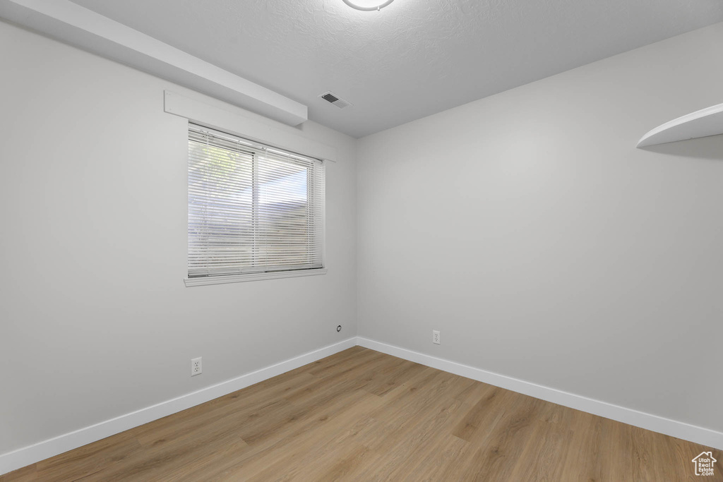 Unfurnished room with baseboards and light wood-type flooring