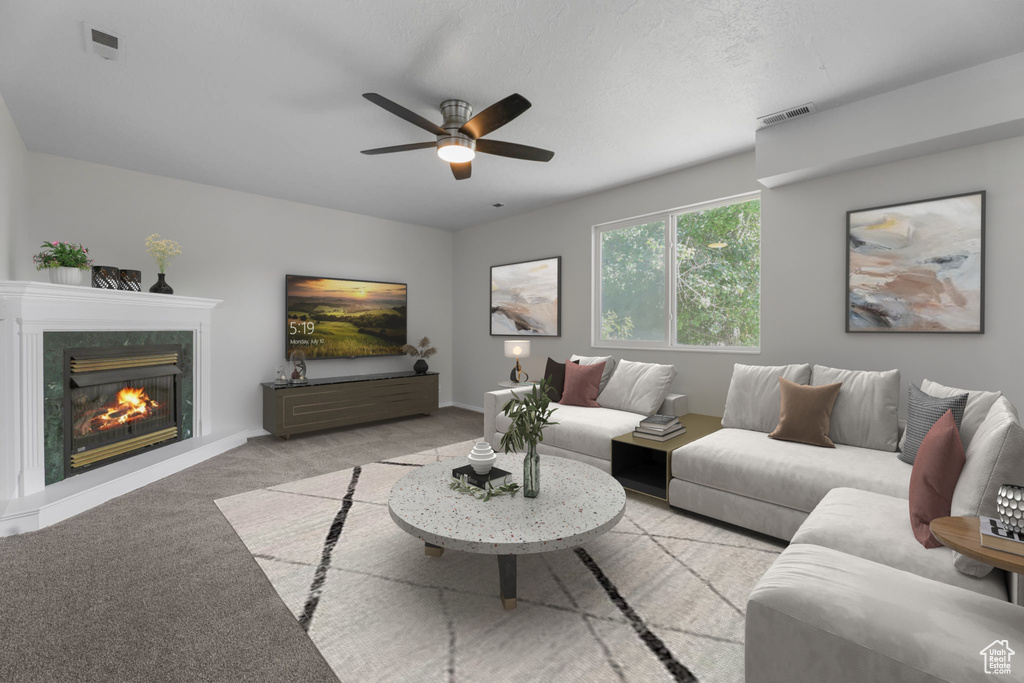 Living room with carpet floors, a ceiling fan, and a fireplace