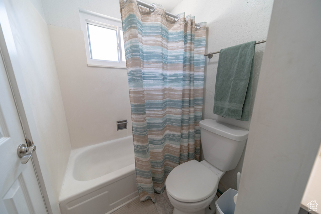 Full bath with toilet and shower / bathtub combination with curtain