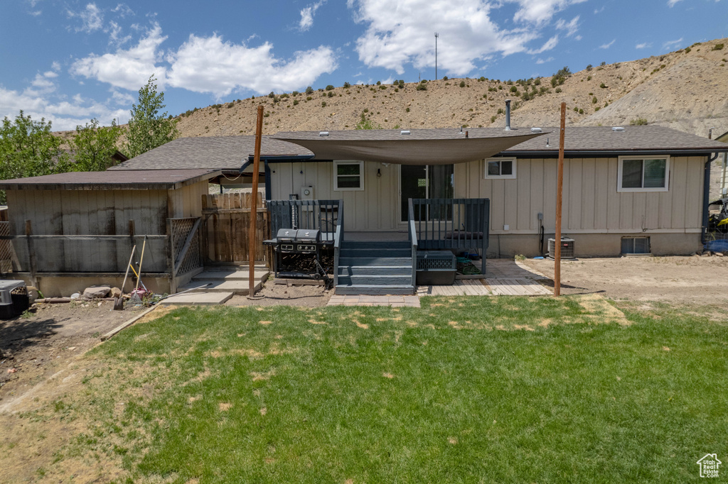 Back of house featuring a deck with mountain view and board and batten siding