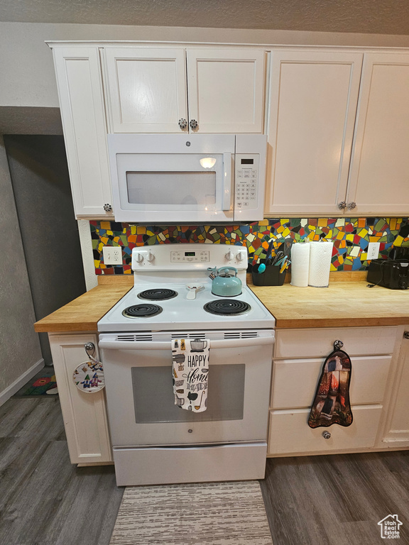 Kitchen featuring white appliances, dark wood-style floors, white cabinets, and butcher block countertops