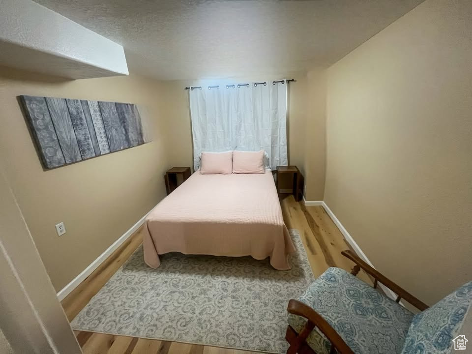 Bedroom featuring wood finished floors and baseboards