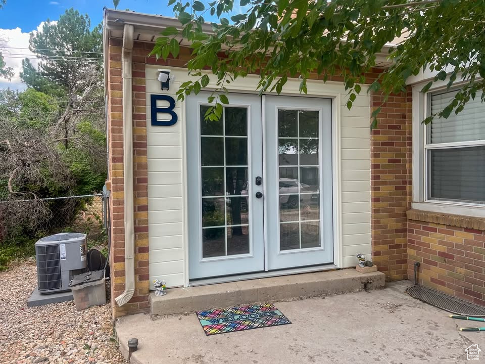 View of exterior entry with french doors and brick siding