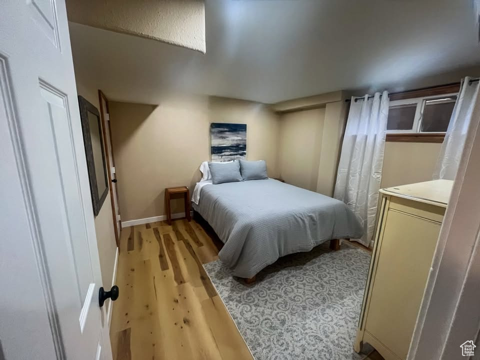 Bedroom with light wood finished floors and baseboards