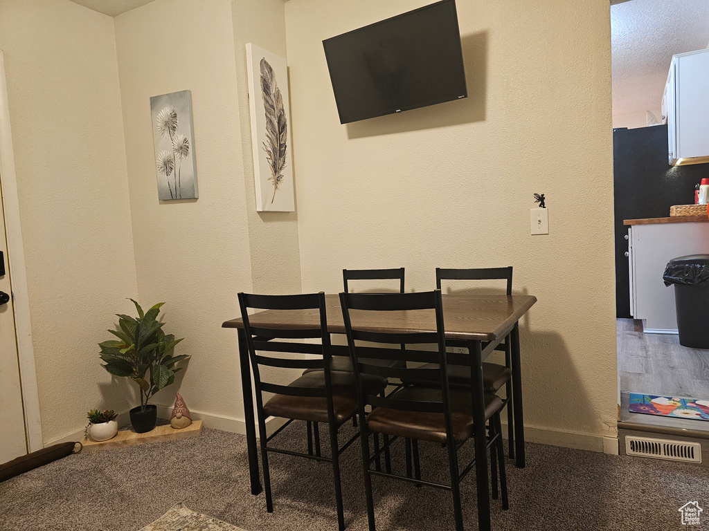 Carpeted dining room featuring baseboards