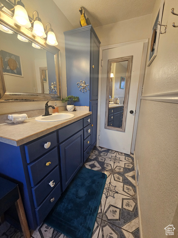 Bathroom featuring vanity and a textured wall