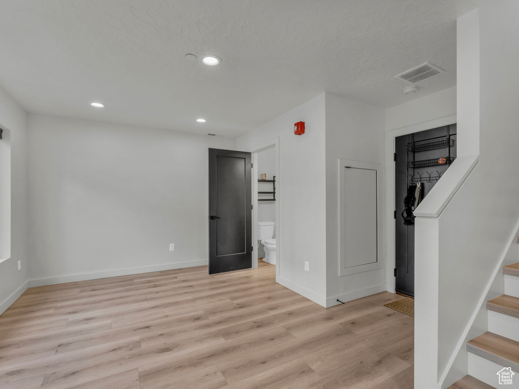 Below grade area featuring light wood-style flooring, stairway, and recessed lighting