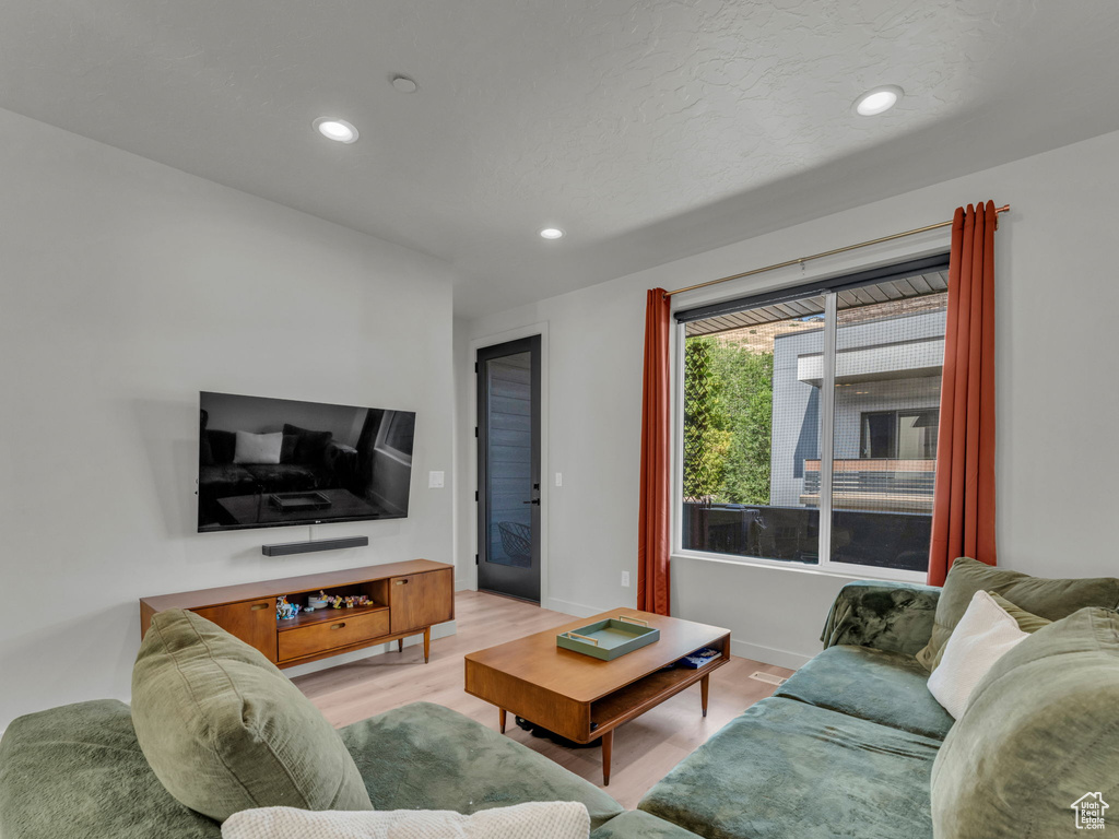 Living area featuring light wood-style floors and recessed lighting