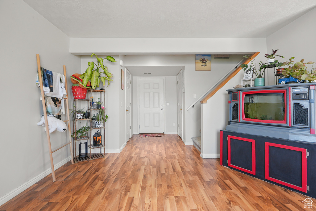 Foyer entrance featuring wood finished floors and stairway