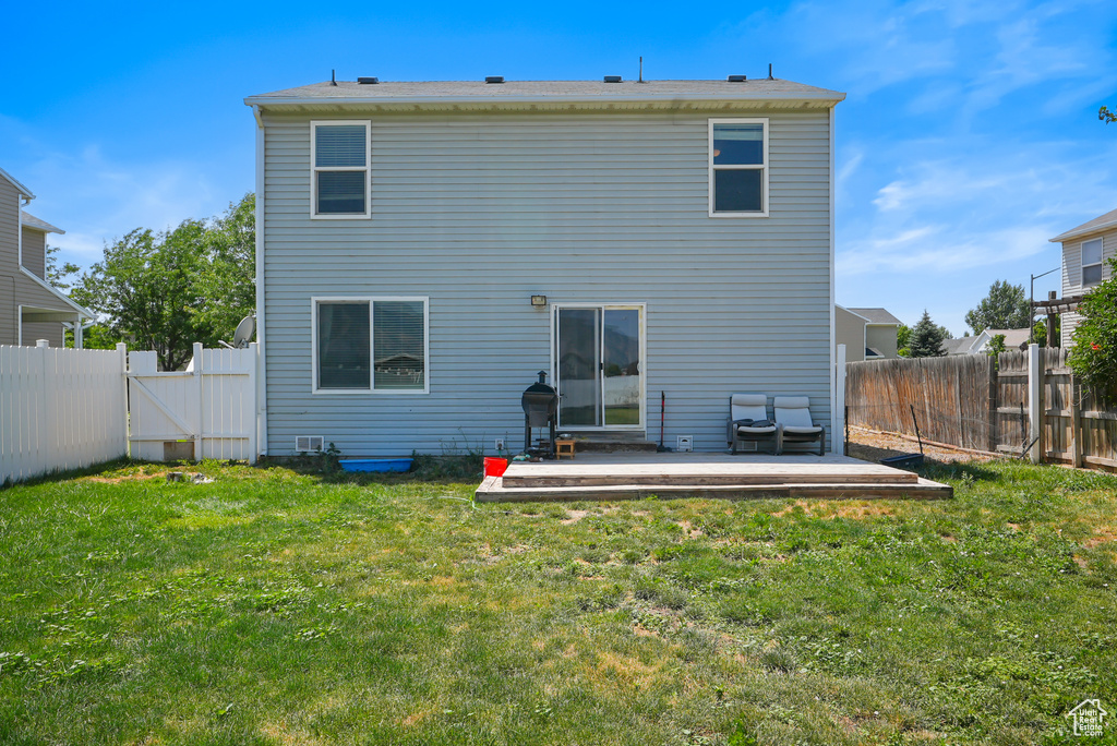 Back of house with a fenced backyard, a gate, and a patio area