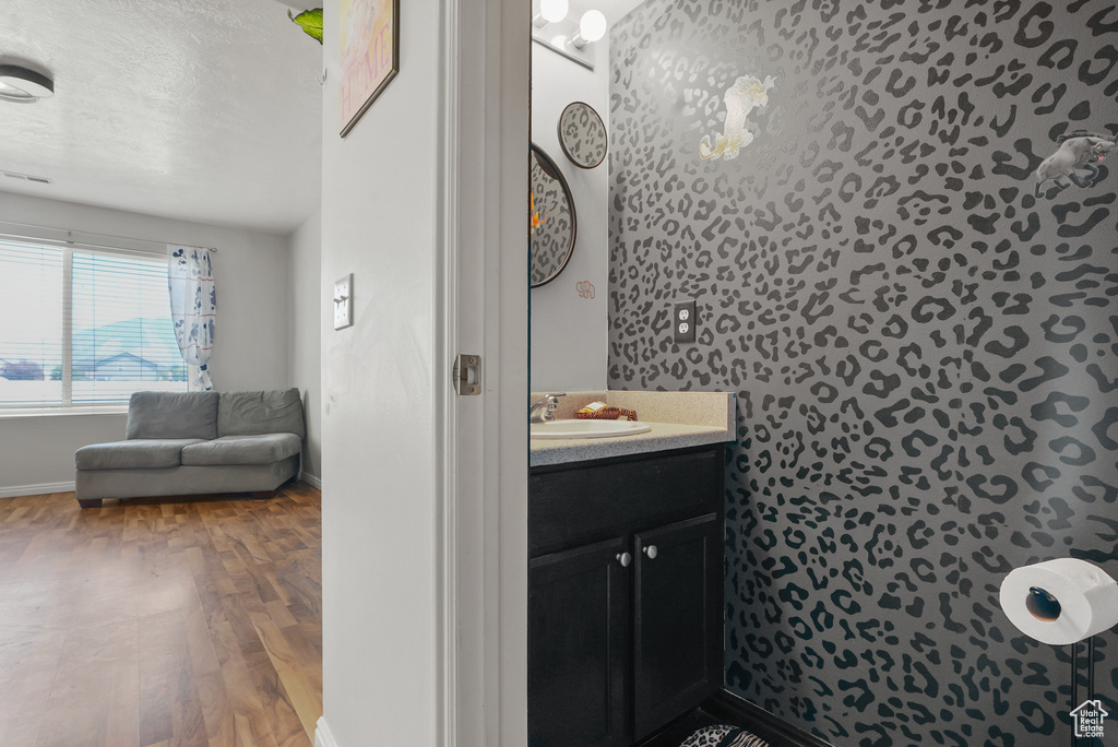 Half bath with vanity and wood finished floors