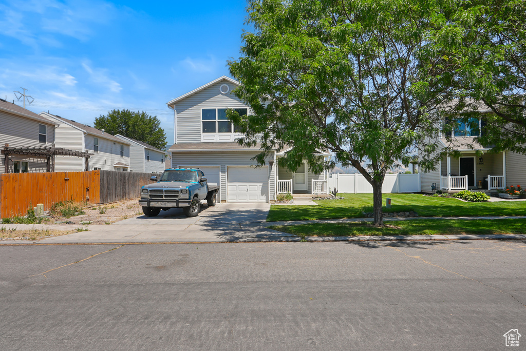 View of front of house featuring concrete driveway and an attached garage