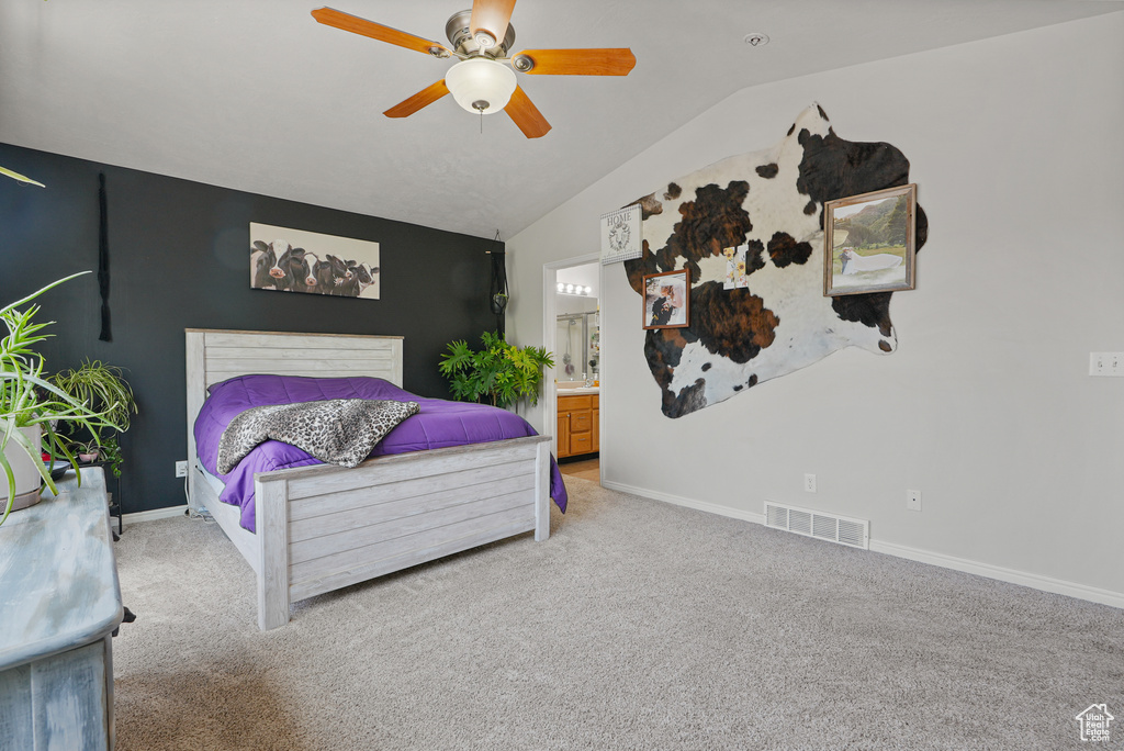 Bedroom with vaulted ceiling, carpet flooring, ceiling fan, and ensuite bath