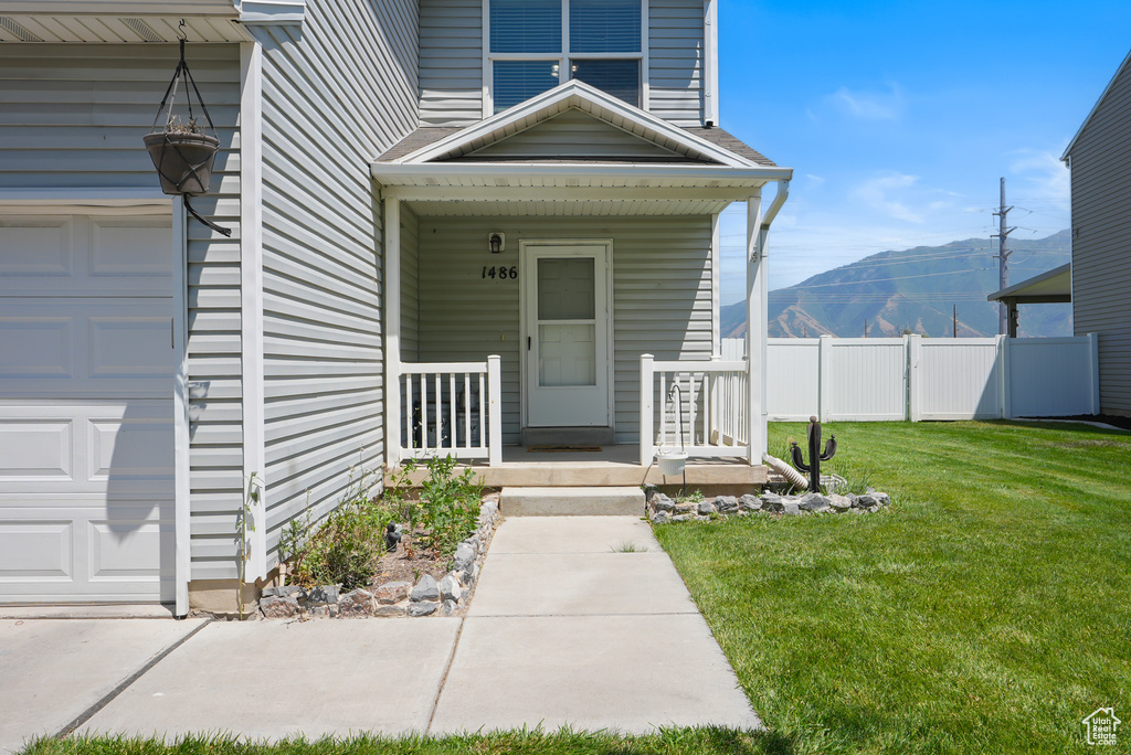 Doorway to property featuring a mountain view, a porch, and an attached garage