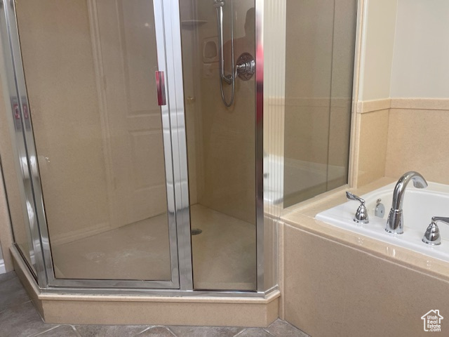 Full bathroom featuring a shower stall, a garden tub, and tile patterned flooring