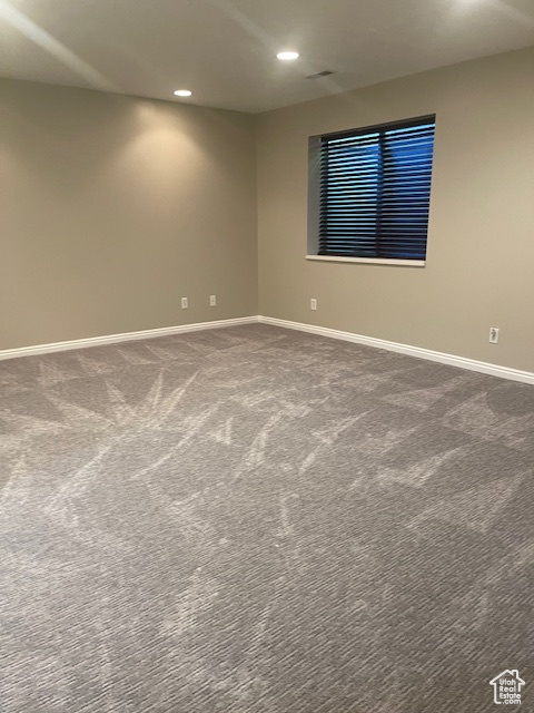 Carpeted spare room featuring baseboards and recessed lighting