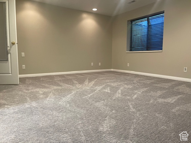 Carpeted empty room featuring baseboards and recessed lighting