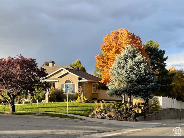 View of front of property with a chimney and stucco siding