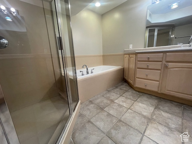 Bathroom featuring a shower stall, vanity, a bath, and recessed lighting