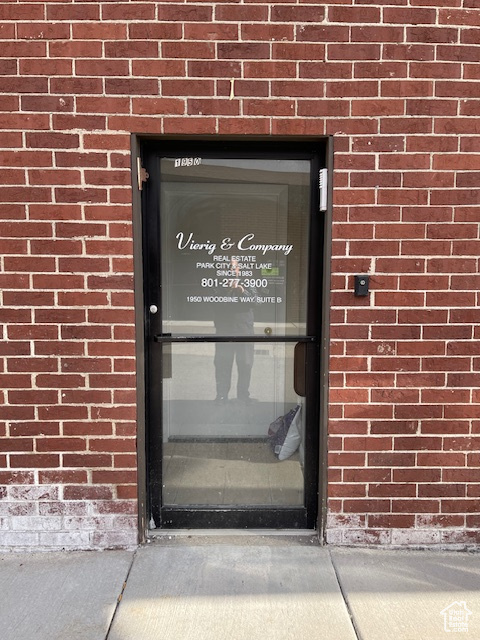 Doorway to property with brick siding