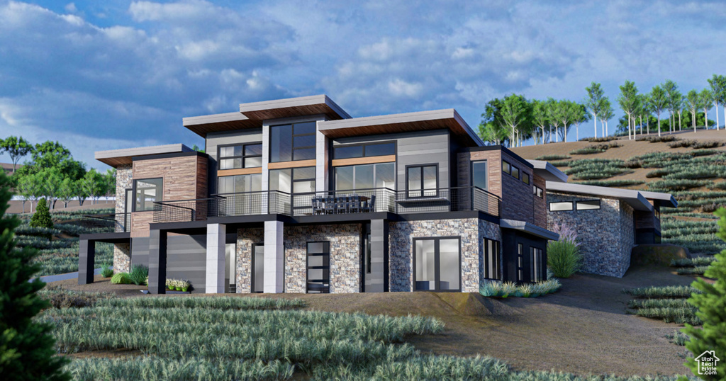 View of front of house featuring a balcony and stone siding