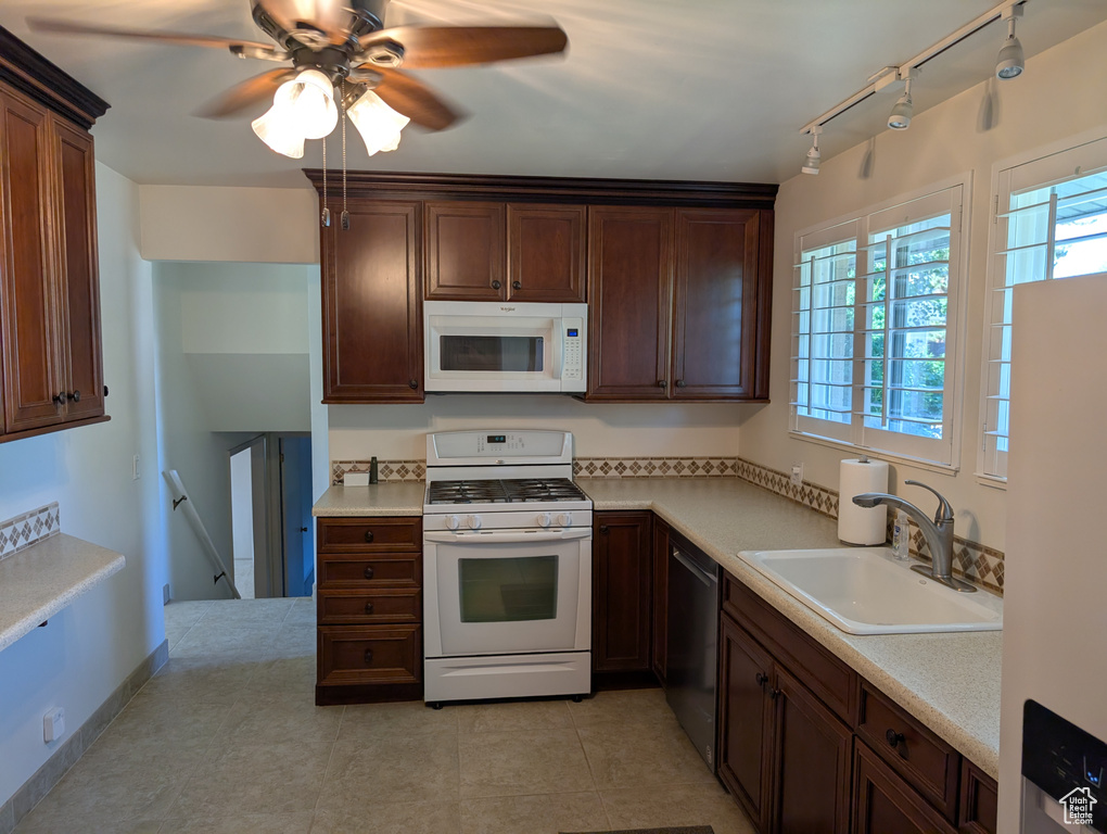 Kitchen featuring white appliances, light countertops, rail lighting, and a ceiling fan