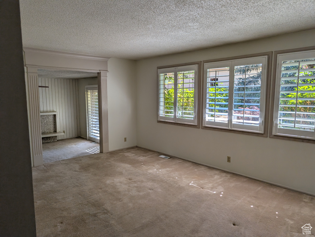 Carpeted spare room with a textured ceiling
