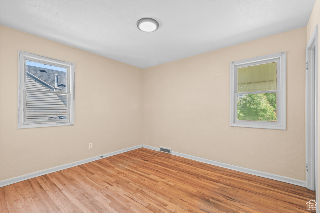Spare room featuring baseboards and light wood finished floors