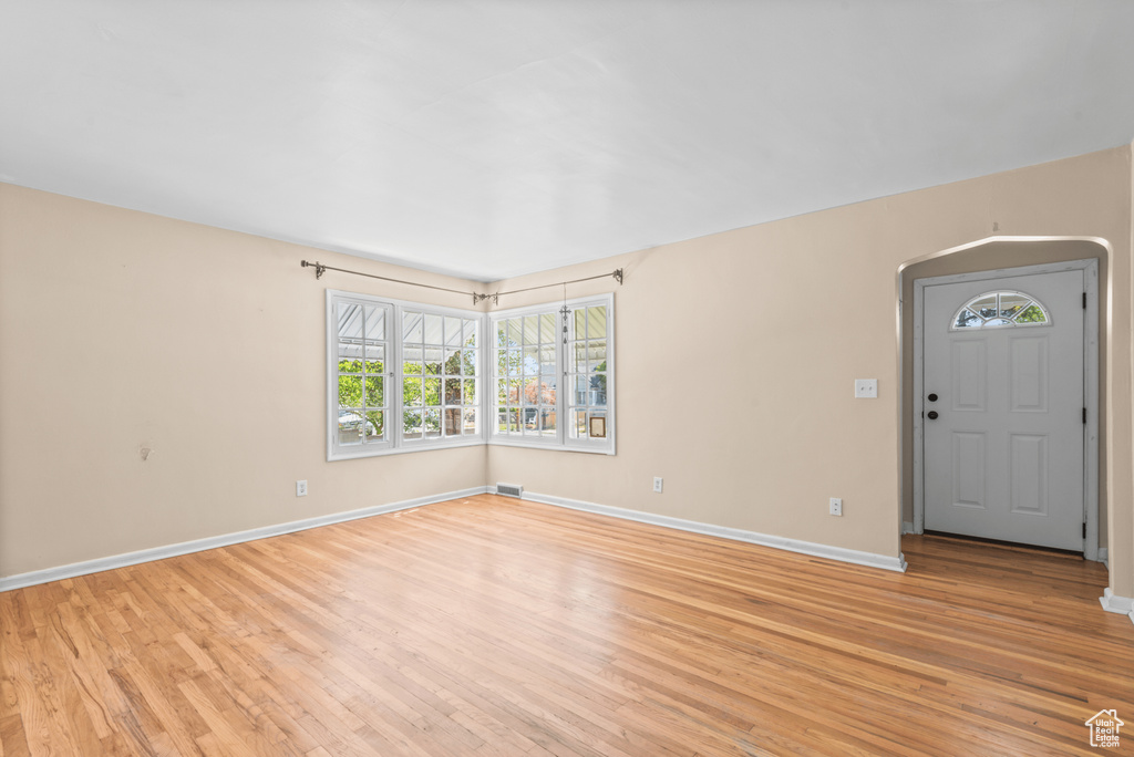 Entryway featuring light wood-type flooring and arched walkways