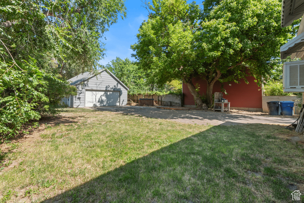 View of green lawn with an outbuilding and a detached garage