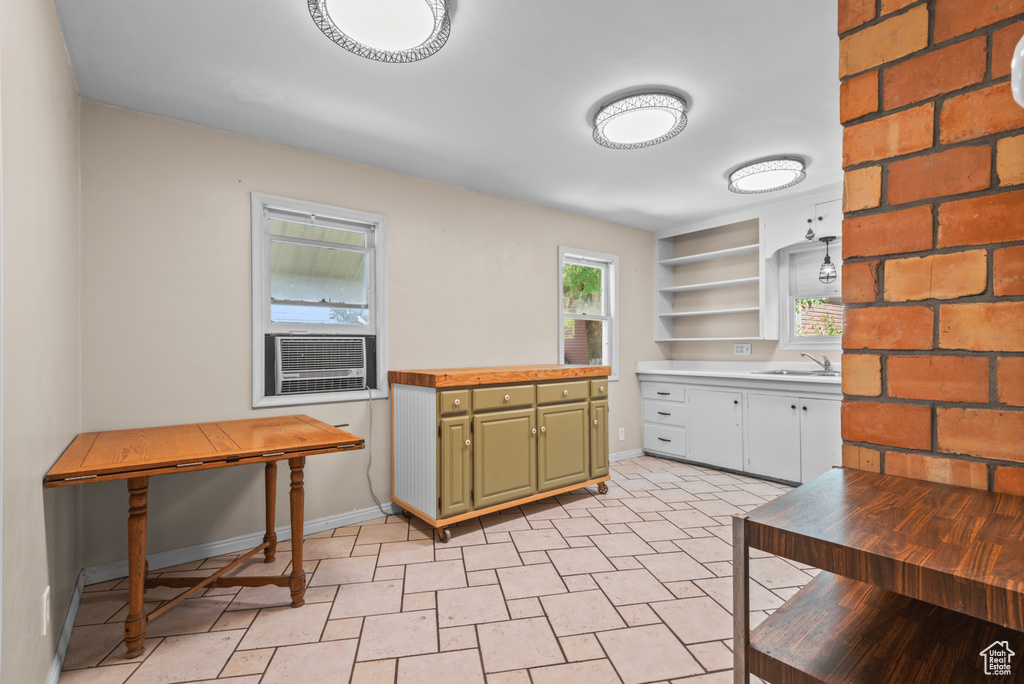 Kitchen with green cabinetry, open shelves, and cooling unit