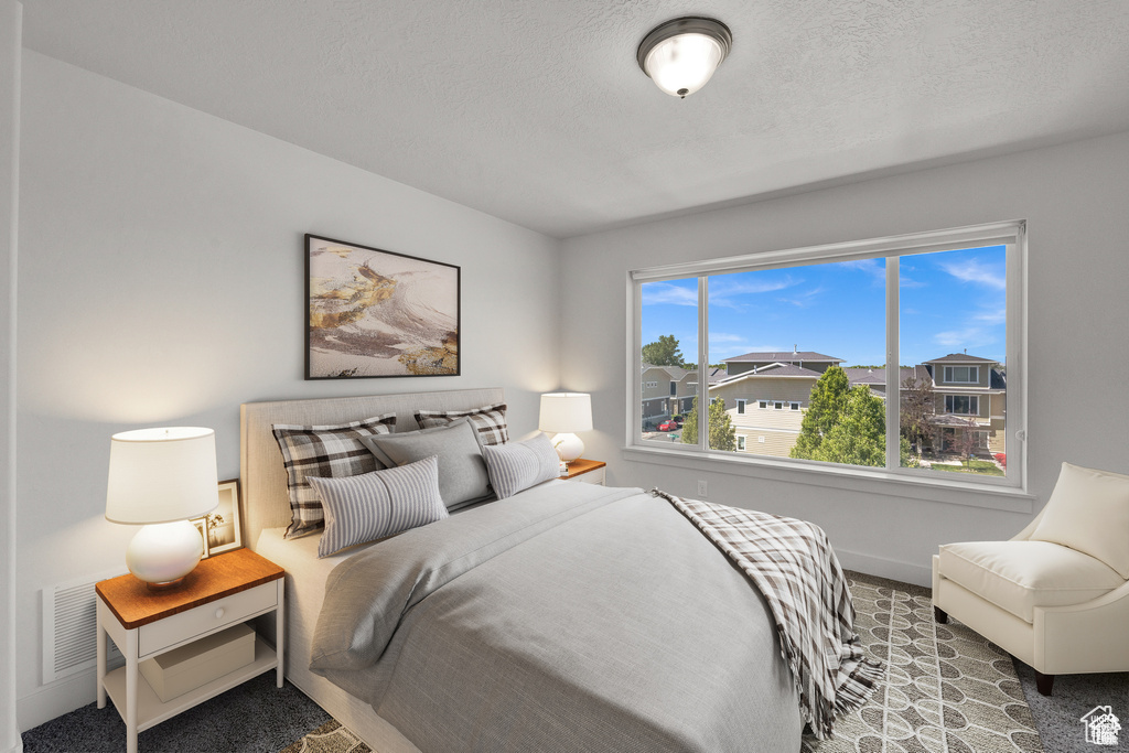 Carpeted bedroom with a textured ceiling