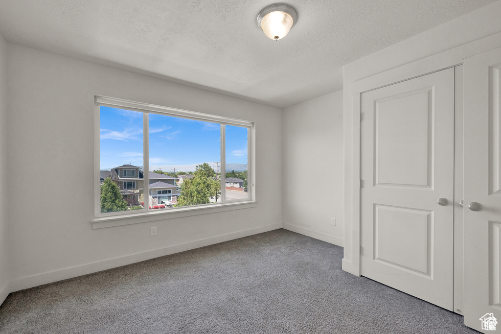 Unfurnished bedroom with carpet floors and baseboards