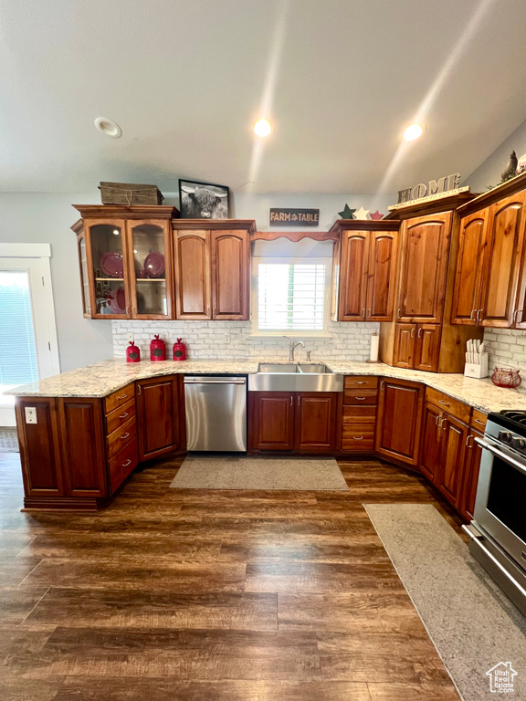 Kitchen with dishwasher, range, glass insert cabinets, backsplash, and dark wood-type flooring