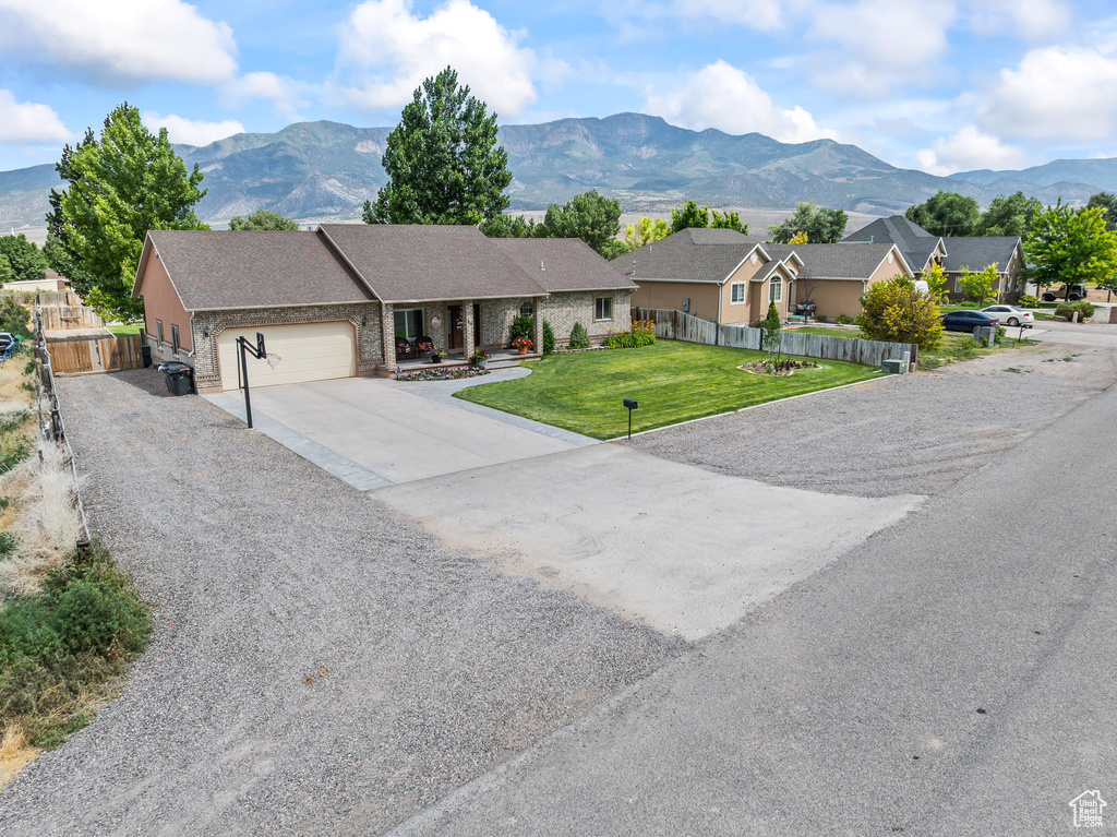 Ranch-style home with driveway, a garage, and a mountain view