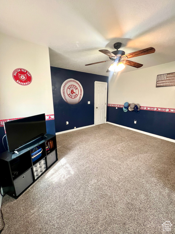 Recreation room featuring a ceiling fan and carpet flooring